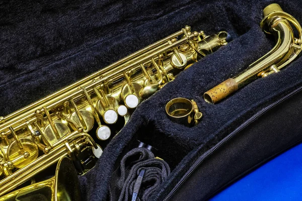 Musical instrument saxophone disassembled lying in a bag on a blue background, saxophone, brass saxophone, Gold saxophone, Musical instrument