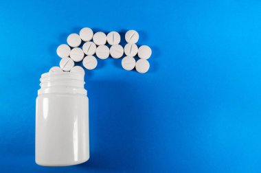 Beyaz ilaç ve şişeli haplar.