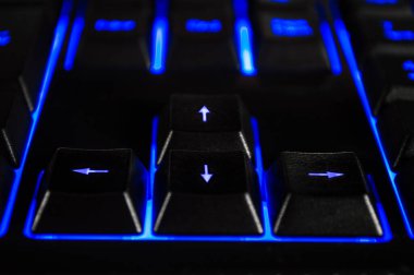 Mavi arka farlı siyah bilgisayar klavyesinin soyut arkaplanı. Bokeh 'le yakın çekim fotoğrafı, duvar kağıdı gibi kullanılabilir..