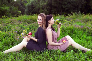 İki kız arkadaş eğleniyor, parkta dinleniyor ve kafede yemek yiyor.