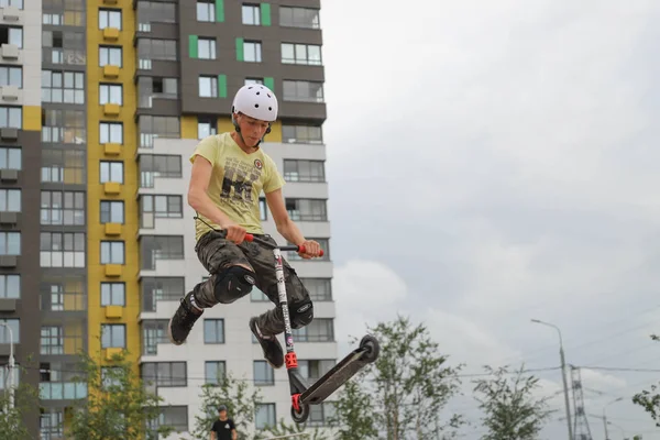 teenager rides a scooter and does tricks