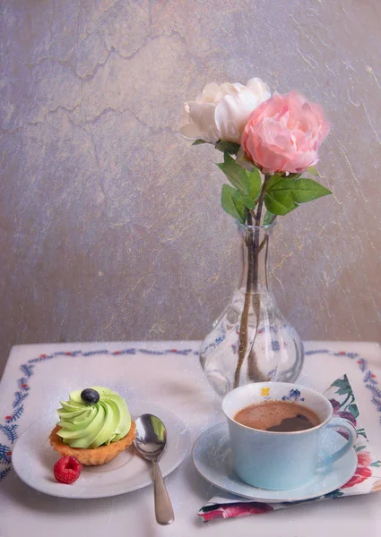 テーブルの上のコーヒーとケーキと花の花瓶 ロイヤリティフリーのストック写真