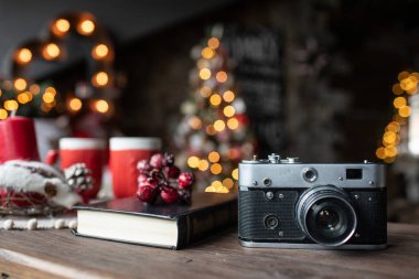 Arka plandaki masada Noel şarkıları ve Noel ağaçları var.