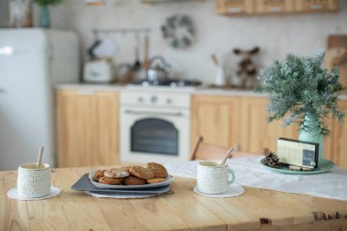 Pastel renkte parlak ve rahat bir mutfak. Mutfak Noel süsüyle süslenmiş. Yeni Yıl