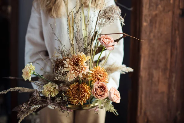 Красивый осенний букет смешанных цветов с сухими ветрами в руках женщины. О работе флориста. Прекрасный букет. Доставка цветов — стоковое фото