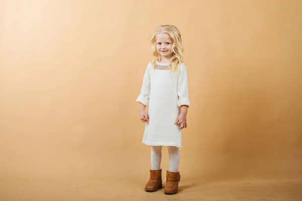 一个穿着白色针织连衣裙的小女孩。 非常好和快乐的女孩 — 图库照片