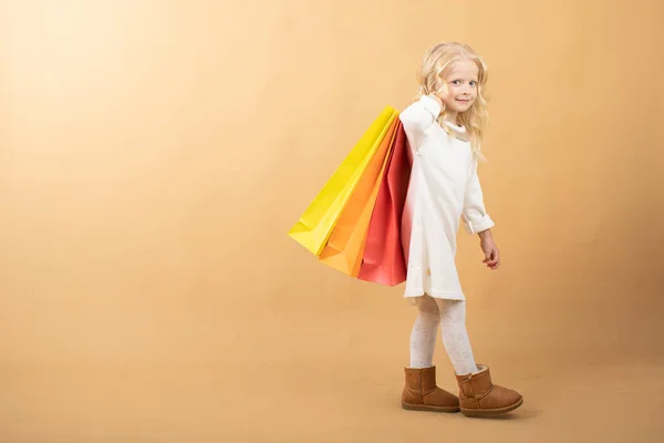 一个穿着白衣，提着购物袋，快乐购物的小女孩 — 图库照片