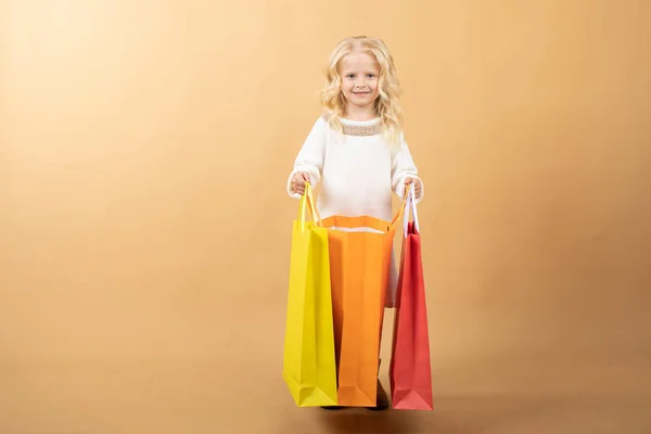 A young girl in a white dress and with shopping bags, happy shopping — Stock Photo, Image