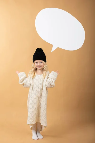 Une fille dans un chapeau se tient sur un fond orange et montre des émotions — Photo