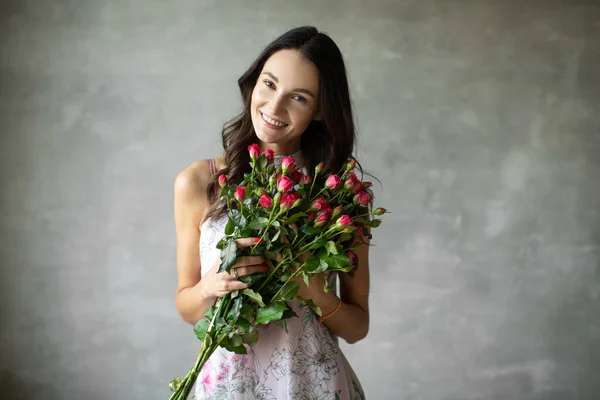 Close-up retrato de atraente jovem mulher no vestido de verão segurando buquê de rosas, menina feliz — Fotografia de Stock