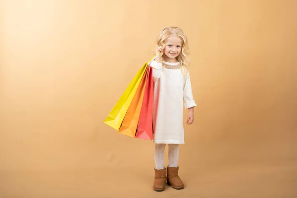 一个穿着白衣，提着购物袋，快乐购物的小女孩 — 图库照片