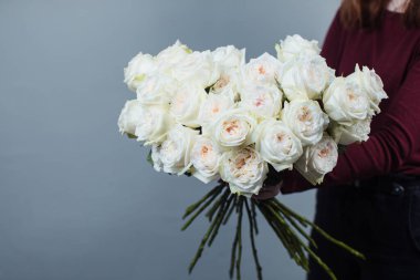 Beyaz güllerin yakın çekimi. Elinde gül tutan bir kız. Çiçekler.