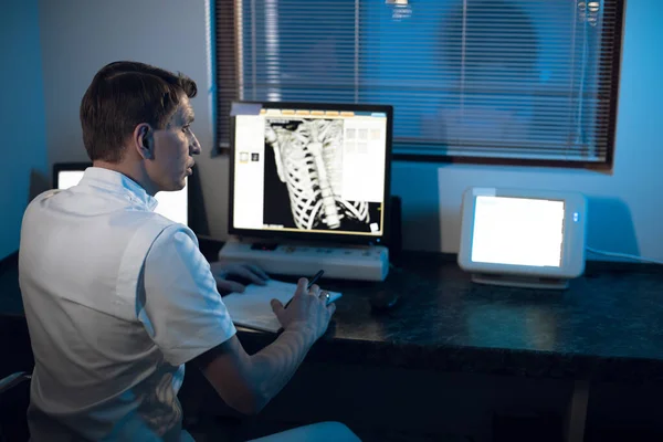 En el Laboratorio Médico el Radiólogo en la Sala de Control supervisa el esqueleto y las costillas del paciente RMN o TC —  Fotos de Stock