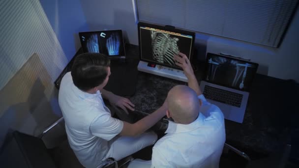 En la sala de control, el médico y el radiólogo discuten el diagnóstico mientras observan el procedimiento. Procedimiento de resonancia magnética o exploración por TC . — Vídeos de Stock