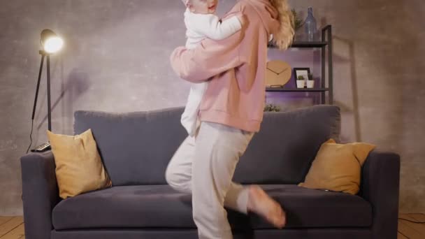 Женщина играет со своим ребенком на диване в уютной квартире. Мама и ребенок счастливы. — стоковое видео