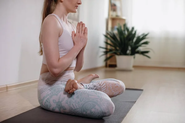 Joven mujer atractiva deportista practicando yoga, meditando en pose de yoga, haciendo ejercicio, usando ropa deportiva, estudio de yoga ligero — Foto de Stock