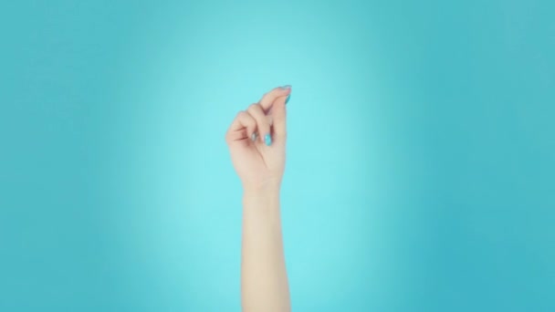Woman hand snaps her fingers over blue background — Stock Video