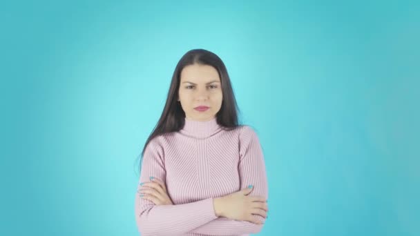 Junge verwirrte Dame steht isoliert vor blauem Hintergrund und schaut Kamera — Stockvideo