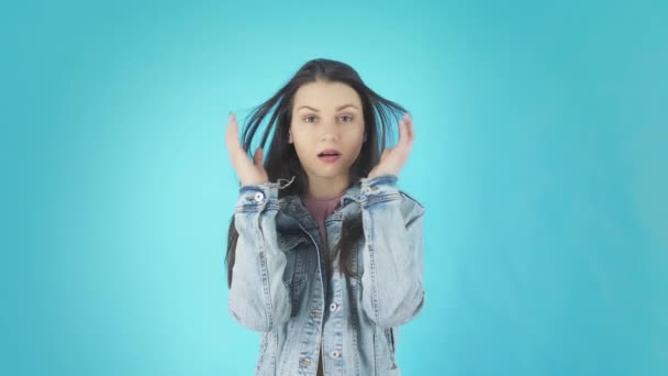 Young Shocked Surprised Woman Standing Isolated Over Blue Background While Looking Camera — Stockvideo