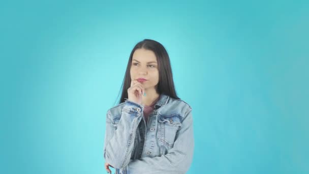 Young worried girl standing with fingers crossed for good luck and wins isolated over blue background — 비디오