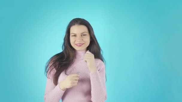 Happy Woman in Pink Shirt dansen en kijken naar de camera over gele achtergrond — Stockvideo