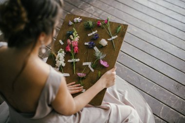 Pembe elbiseli bir kız Tahtadaki Taze Çiçeklere bakar