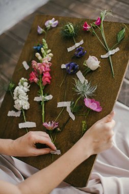 Pembe elbiseli bir kız Tahtadaki Taze Çiçeklere bakar