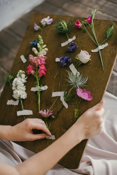 Pembe elbiseli bir kız Tahtadaki Taze Çiçeklere bakar