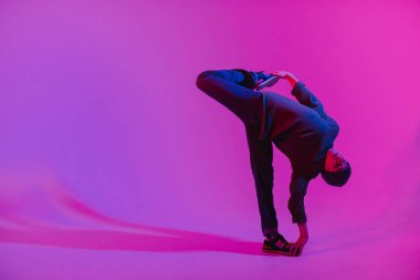 Jumperlı Genç Adam Stüdyoda Çağdaş Dans Ediyor. Breakdance. Dans okulu posteri. Uzayı kopyala Savaş yarışması duyurusu. Pembe ve Mavi Arkaplan.