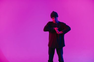 Jumperlı Genç Adam Stüdyoda Çağdaş Dans Ediyor. Breakdance. Dans okulu posteri. Uzayı kopyala Savaş yarışması duyurusu. Pembe ve Mavi Arkaplan.