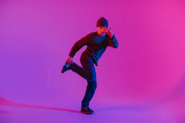 Jumperlı Genç Adam Stüdyoda Çağdaş Dans Ediyor. Breakdance. Dans okulu posteri. Uzayı kopyala Savaş yarışması duyurusu. Pembe ve Mavi Arkaplan.