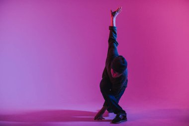 Jumperlı Genç Adam Stüdyoda Çağdaş Dans Ediyor. Breakdance. Dans okulu posteri. Uzayı kopyala Savaş yarışması duyurusu. Pembe ve Mavi Arkaplan.