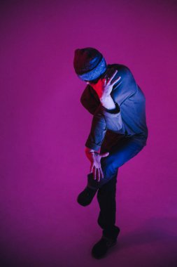 Jumperlı Genç Adam Stüdyoda Çağdaş Dans Ediyor. Breakdance. Dans okulu posteri. Uzayı kopyala Savaş yarışması duyurusu. Pembe ve Mavi Arkaplan.