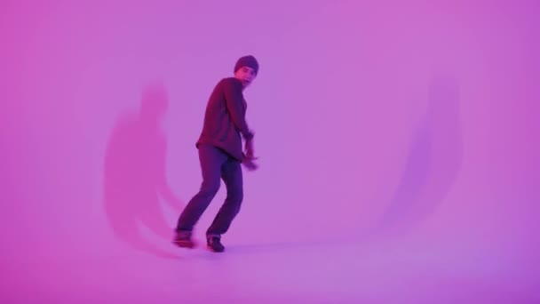 Young Man in a Jumper Dancing Contemporary Dance in Studio (em inglês). Breakdancing. Cartaz da Escola de Dança. Espaço Copiar. Anúncio da competição. Fundo rosa e azul. — Vídeo de Stock