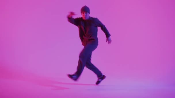 Young Man in a Jumper Dancing Contemporary Dance in Studio. Bailando Breakdance. Cartel de la escuela de baile. Copiar espacio. Anuncio de competencia de batalla. Fondo rosa y azul. — Vídeo de stock