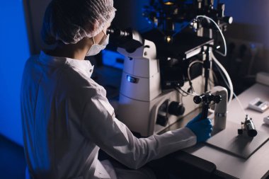 Modern bir Laboratuvar Bilimadamı Davranış Deneylerinde. Baş Araştırmacı Bilim Adamı Petri Çanağı 'nda Örnek Ayarladı ve Mikroskoba Baktı.