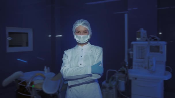 年轻女医生的肖像，戴着医疗面罩，看着相机 — 图库视频影像