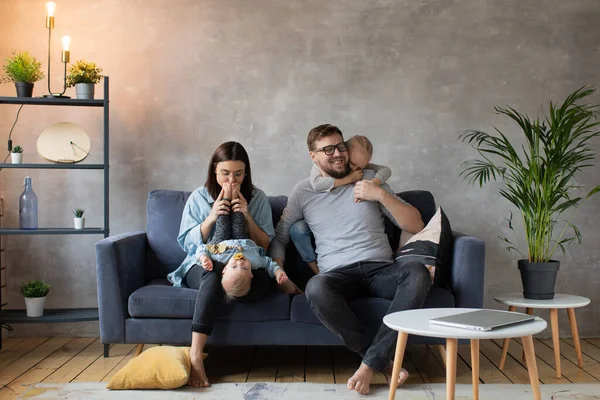 Joven familia jugando juntos en el sofá. familia feliz. comodidad en el hogar . — Foto de Stock