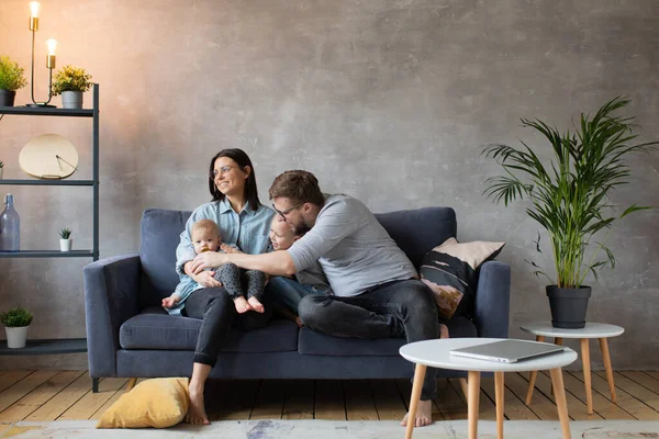Joven familia jugando juntos en el sofá. familia feliz. comodidad en el hogar . — Foto de Stock