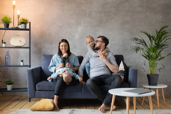 Joven familia jugando juntos en el sofá. familia feliz. comodidad en el hogar . — Foto de Stock