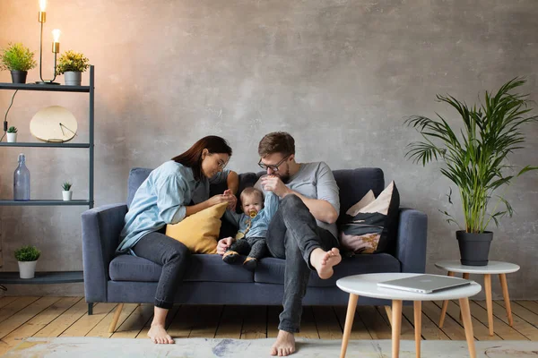 Joven familia jugando juntos en el sofá. familia feliz. comodidad en el hogar . — Foto de Stock