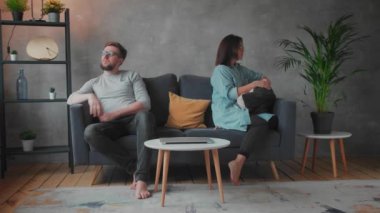Genç bir çift evdeki tartışmadan sonra koltukta oturuyor. Karı ve koca sırt sırta otururlar. Sosyal Video.