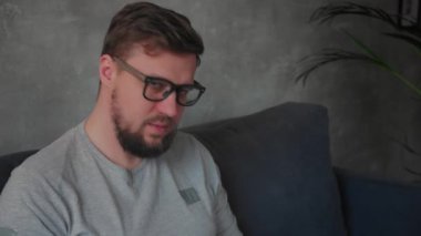 Gözlüklü genç sakallı adam bir dizüstü bilgisayar üzerinde çalışıyor. Bağımsız.