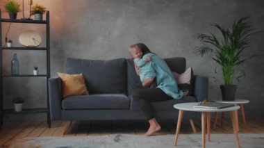 Genç Anne Kanepede Çocuklarla Oynuyor. Mutlu bir aile. ev konforu.