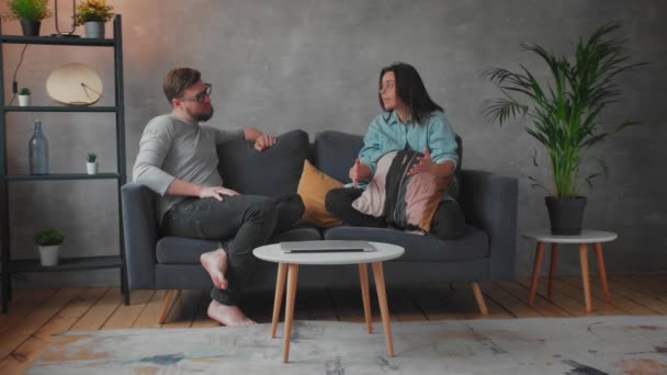 Jeune couple se disputant sur le canapé à la maison. La femme crie sur son mari. Vidéo sociale. Agression, répression . — Video