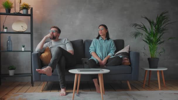 Young Couple Sitting on the Sofa. The Woman Tears Up The Photo. Family Conflict. — Stockvideo