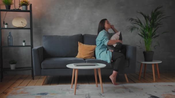 A young Girl is Sitting on the Sofa Hugging a Pillow. Depressed and Upset Woman. Social video — Stock Video