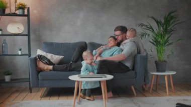Genç Aile Koltukta Birlikte Oynuyor. Mutlu bir aile. ev konforu.