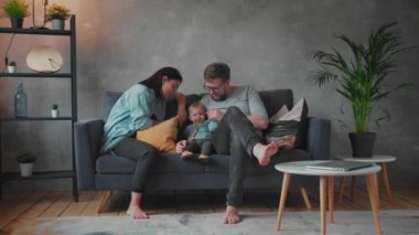 Genç Aile Koltukta Birlikte Oynuyor. Mutlu bir aile. ev konforu.