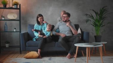 Genç Aile Koltukta Birlikte Oynuyor. Mutlu bir aile. ev konforu.